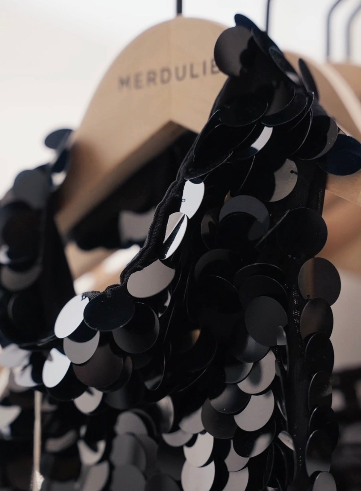 Black and white sequin garment on a mannequin with blurred background