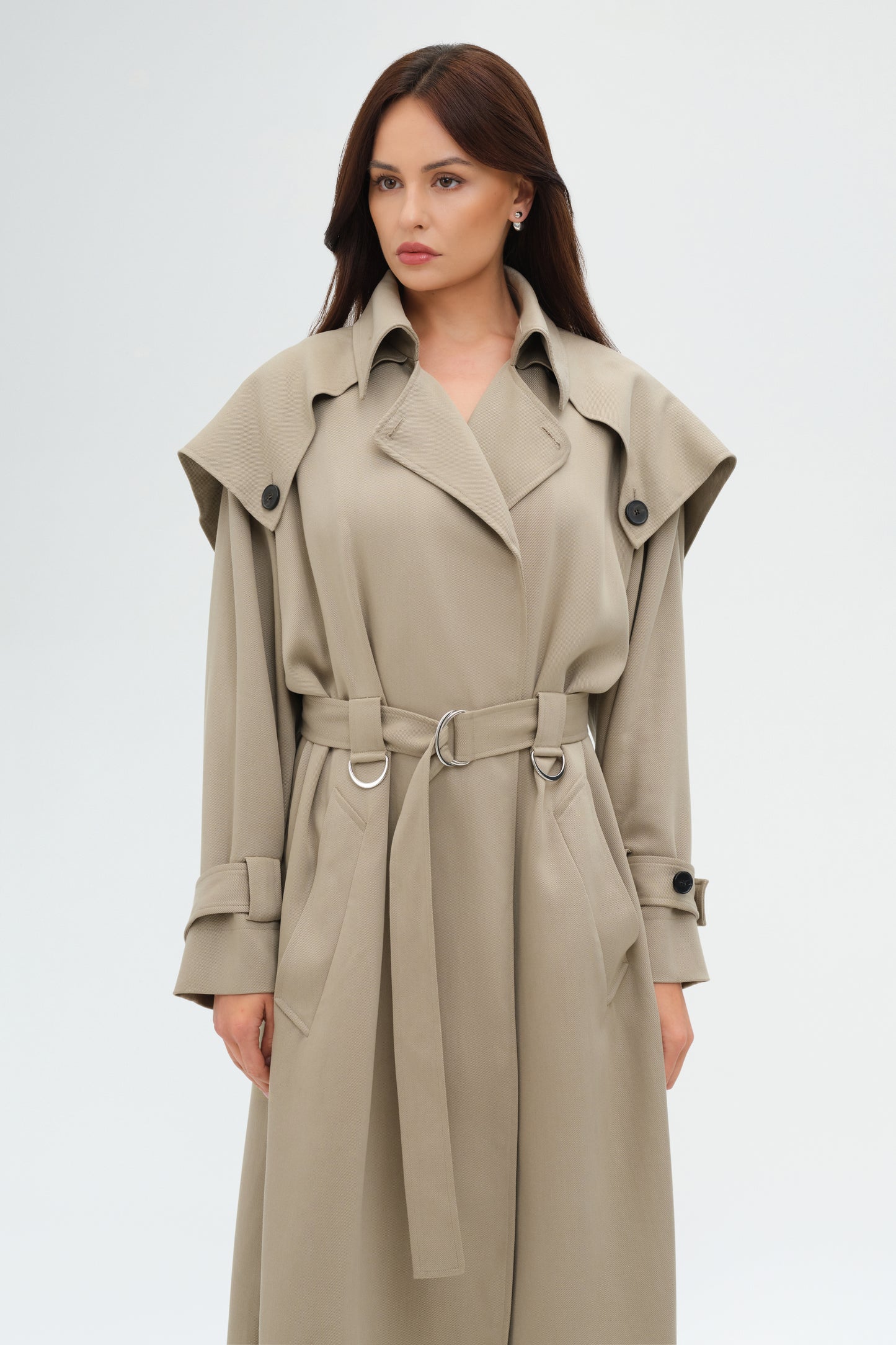 Woman wearing a beige trench coat on a white background