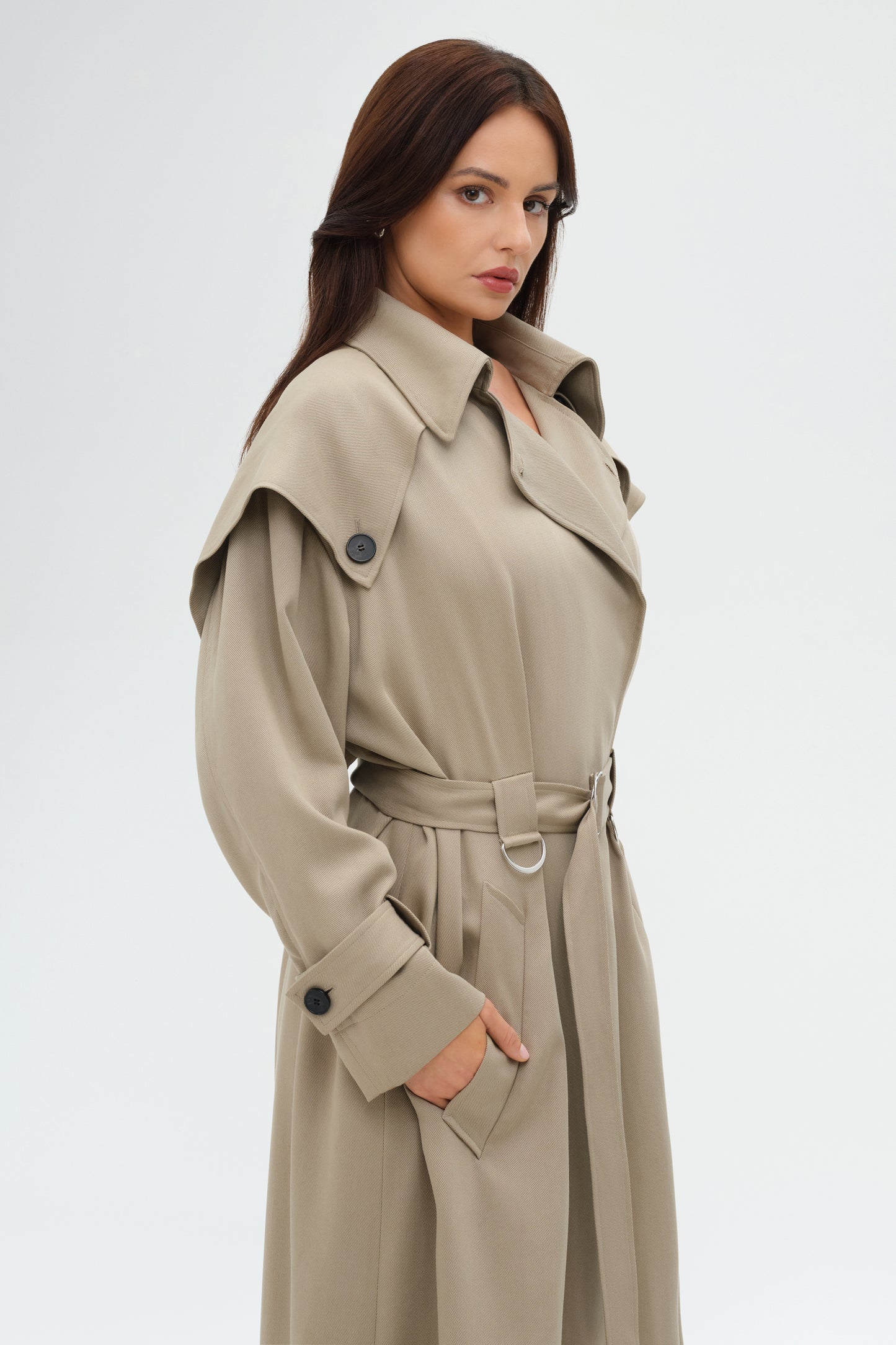 Woman wearing a beige trench coat on a white background