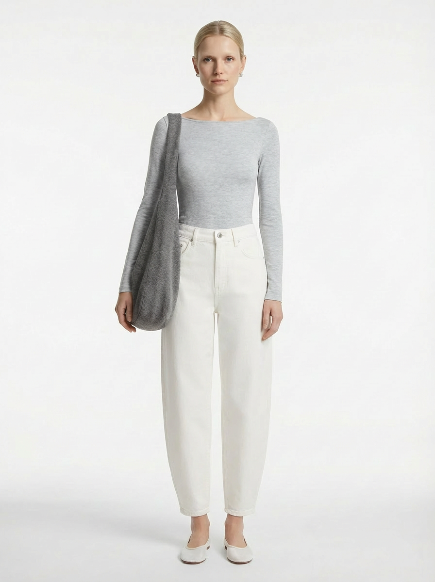 Woman wearing a gray sweater and white pants on a white background
