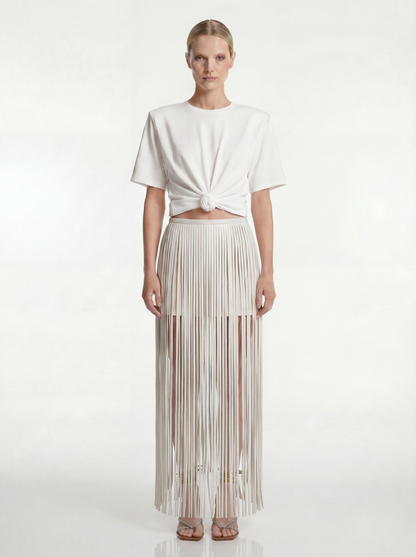 Woman wearing a white top and pleated skirt on a white background
