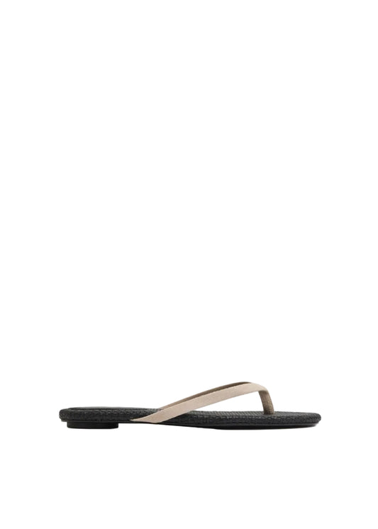 Black sandal with beige strap on a light gray background