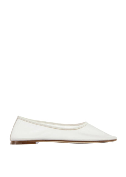 White flat shoe on a light beige background
