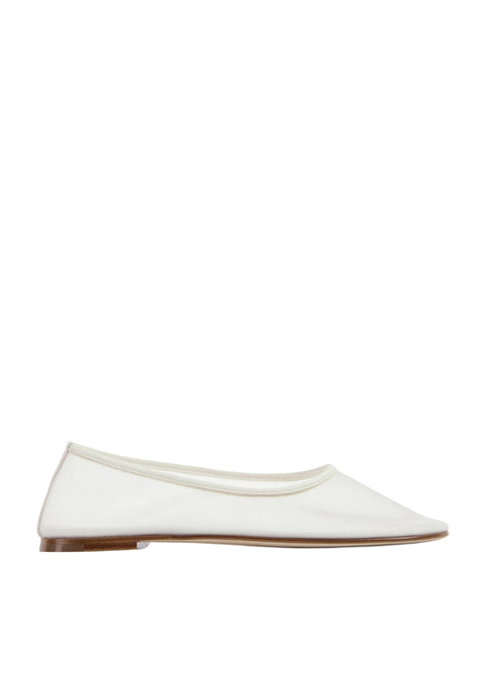 White flat shoe on a light beige background