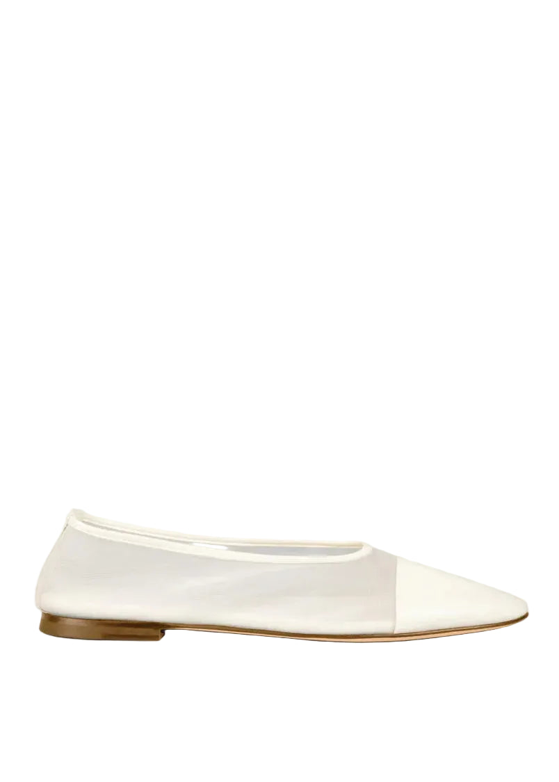 White flat shoe with a brown sole on a white background
