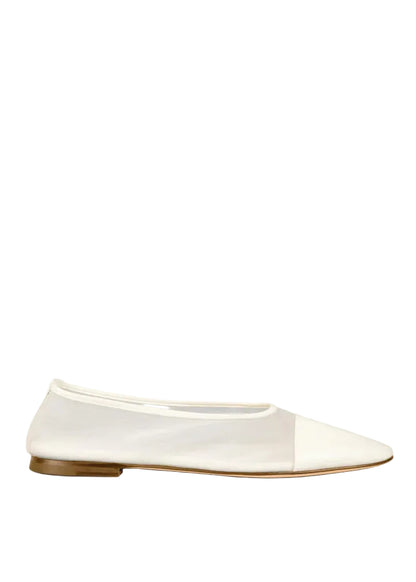 White flat shoe with a brown sole on a white background